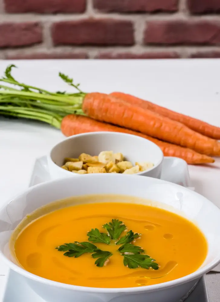 Velouté de carottes fait maison : soupe onctueuse riche en bêta-carotène servie avec persil et croûtons