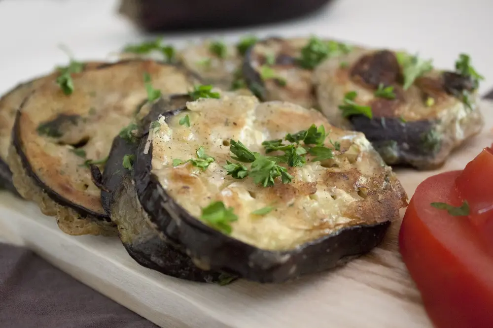 Aubergines grillées à l'ail et persil sur assiette - recette cuisine méditerranéenne légumes bio