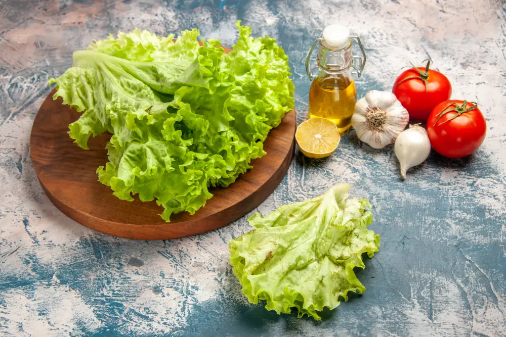 Scarole fraîche sur planche bois avec huile olive, tomates et ail pour salade chicorée cuisine méditerranéenne