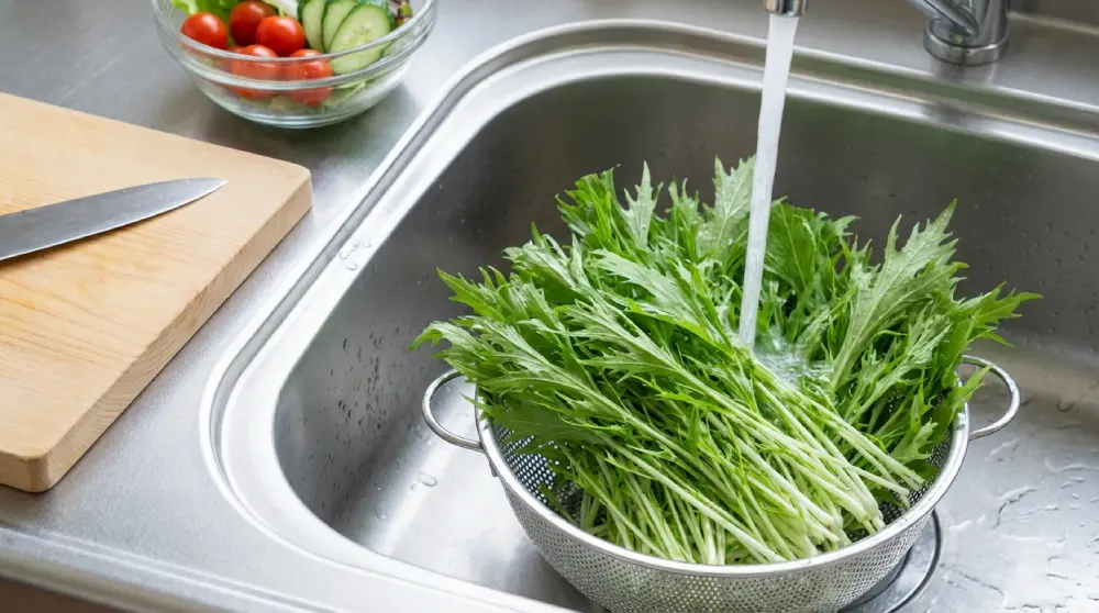 Mizuna fraîche rincée dans une passoire sous l'eau, prête à cuisiner en salade